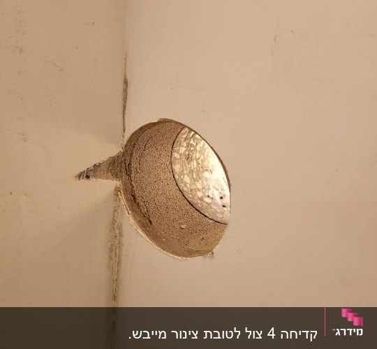 חור בקיר בטון עם צינור מתכת